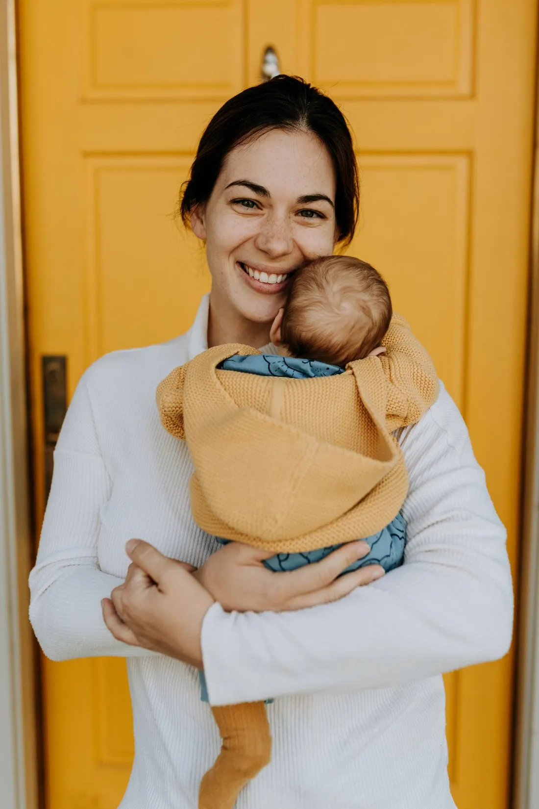 Lächelnde Mutter hält ihr Baby im Arm