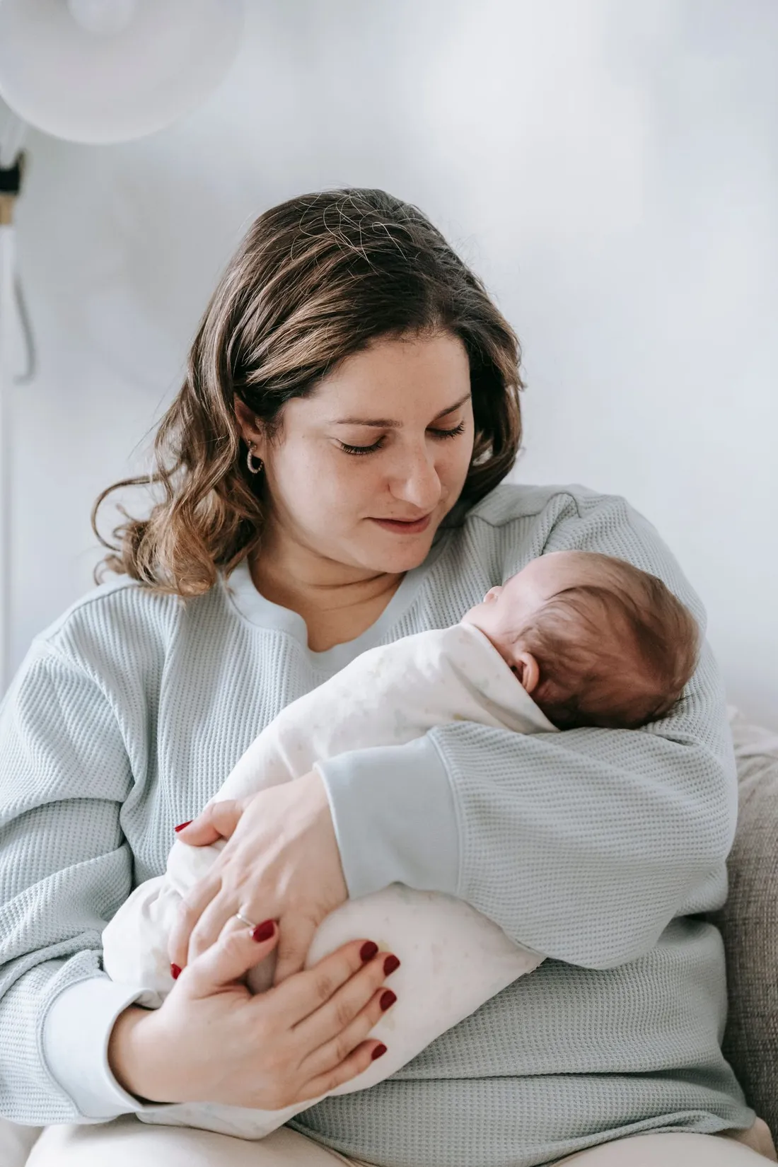 Mutter hält ihr Neugeborenes im Arm